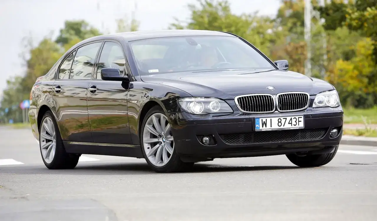 Eleganckie czarne BMW 730d z polskimi tablicami WI 8743F jedzie po ulicy.