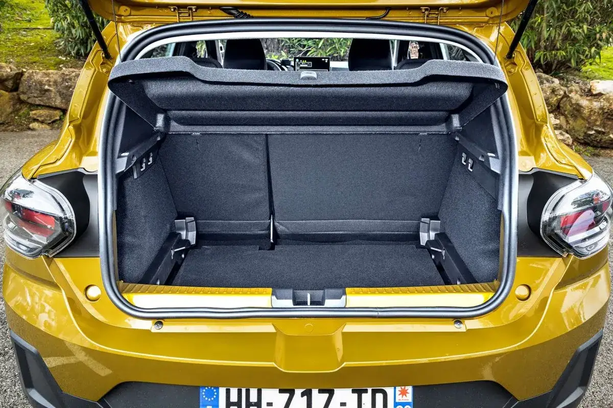 Otwarty bagażnik żółtego Sandero Stepway. Wnętrze jest puste, gotowe na bagaże z wakacyjnej podróży.