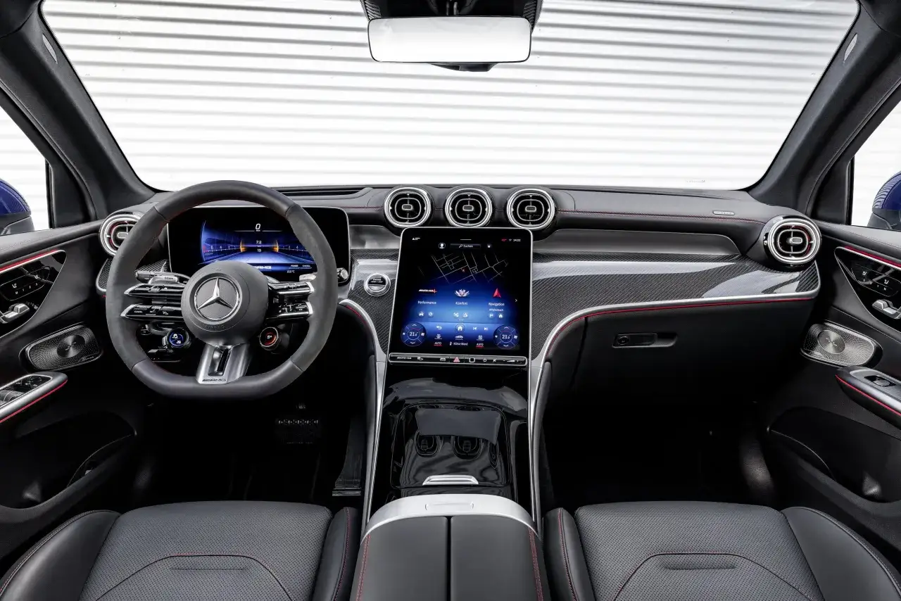 Wnętrze Mercedesa GLC 200 z cyfrowymi zegarami, dużym ekranem dotykowym i sportową kierownicą.