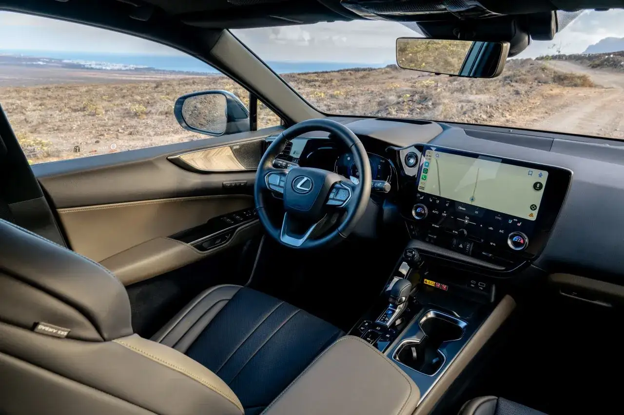 Wnętrze Lexus NX 350h z nowoczesnym ekranem multimedialnym i komfortowymi siedzeniami, gotowe na podróż przez pustynny krajobraz.