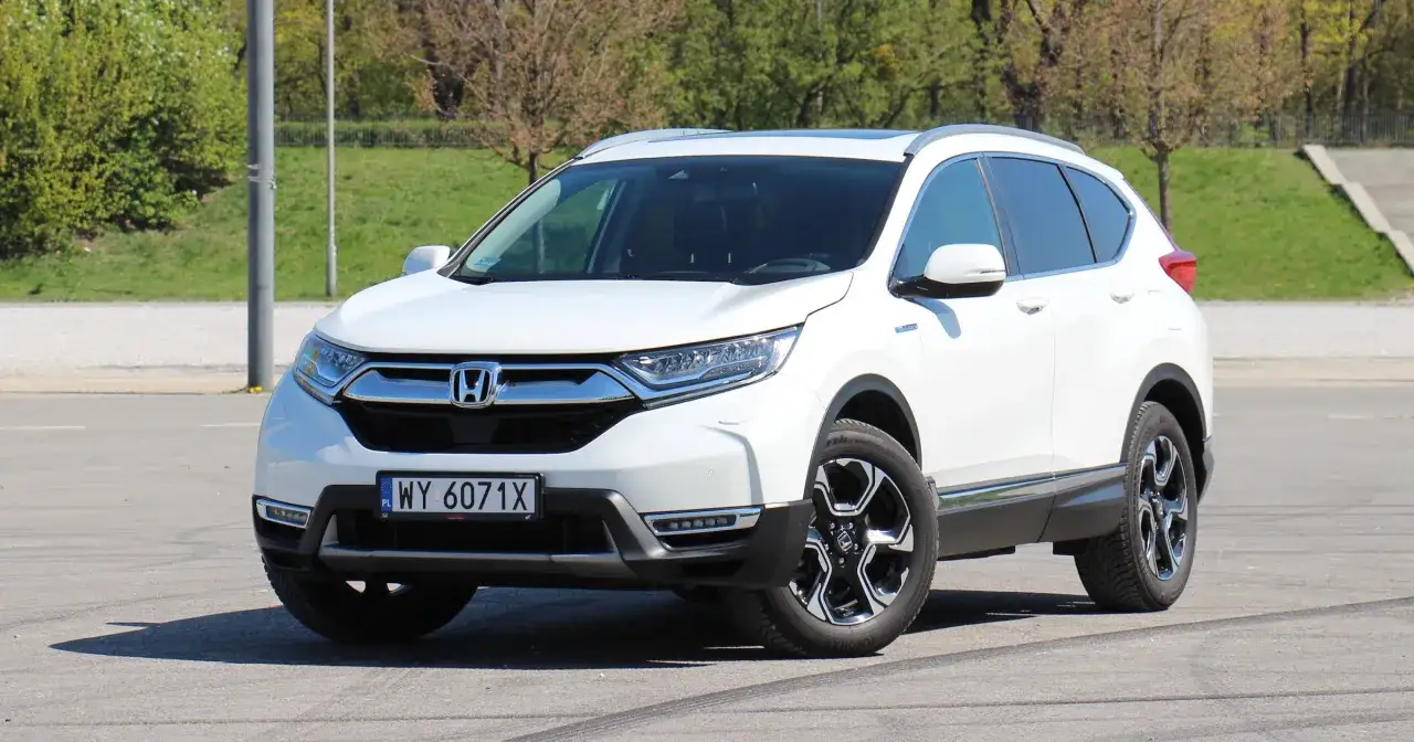 Biała Honda CR-V 2.0 benzyna z eleganckimi felgami stoi na parkingu.
