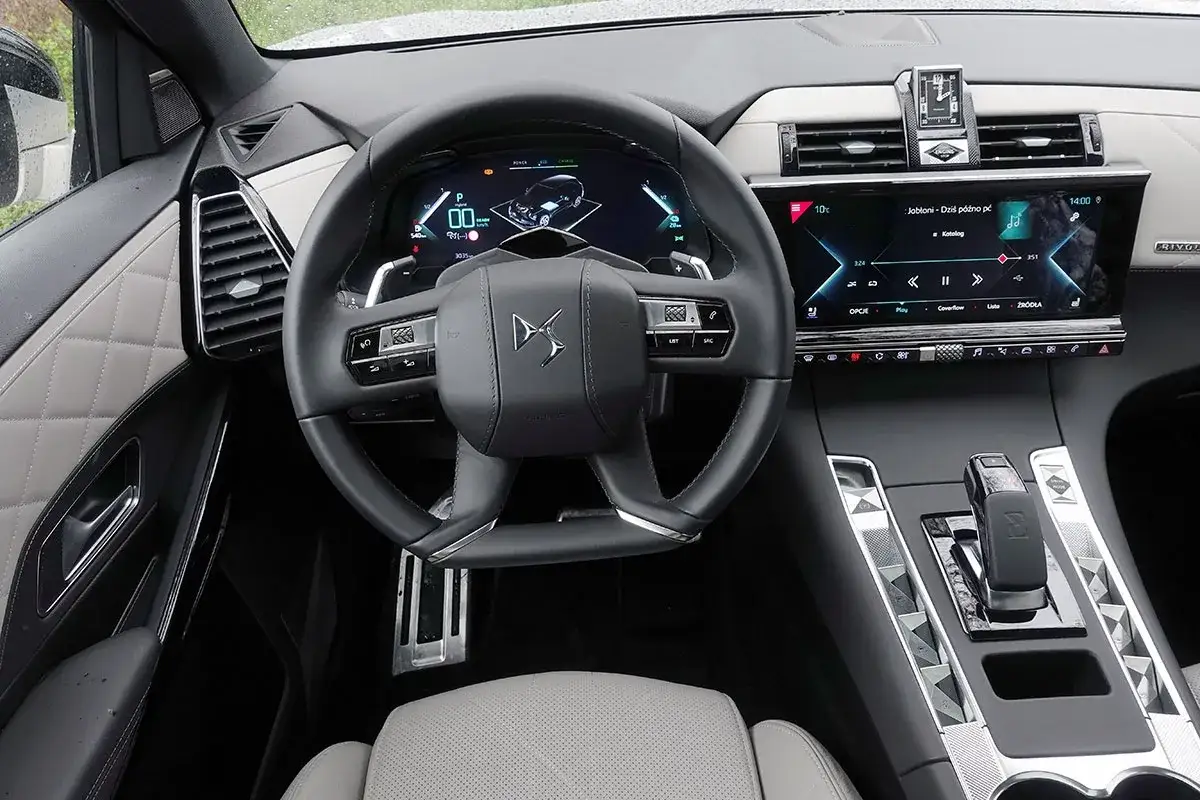 Wnętrze Citroëna DS7 z cyfrowym kokpitem i ekranem multimediów. Eleganckie pikowane detale na drzwiach i desce rozdzielczej.