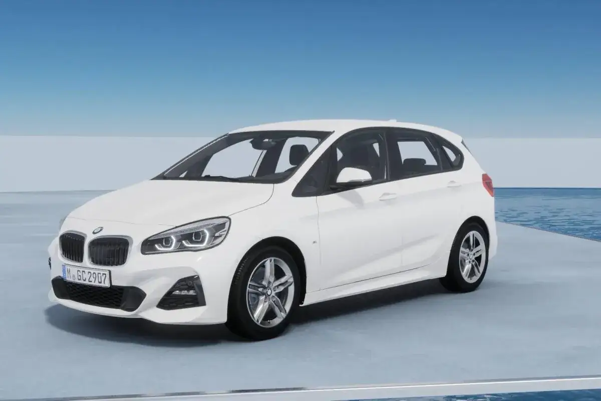 Białe BMW F45 z tablicą rejestracyjną M.GC 2907 stoi na tle błękitnego nieba i wody.