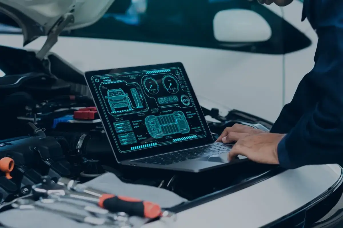 Diagnostyka elektrycznego pojazdu na laptopie, szukając przyczyn nierównej pracy silnika.