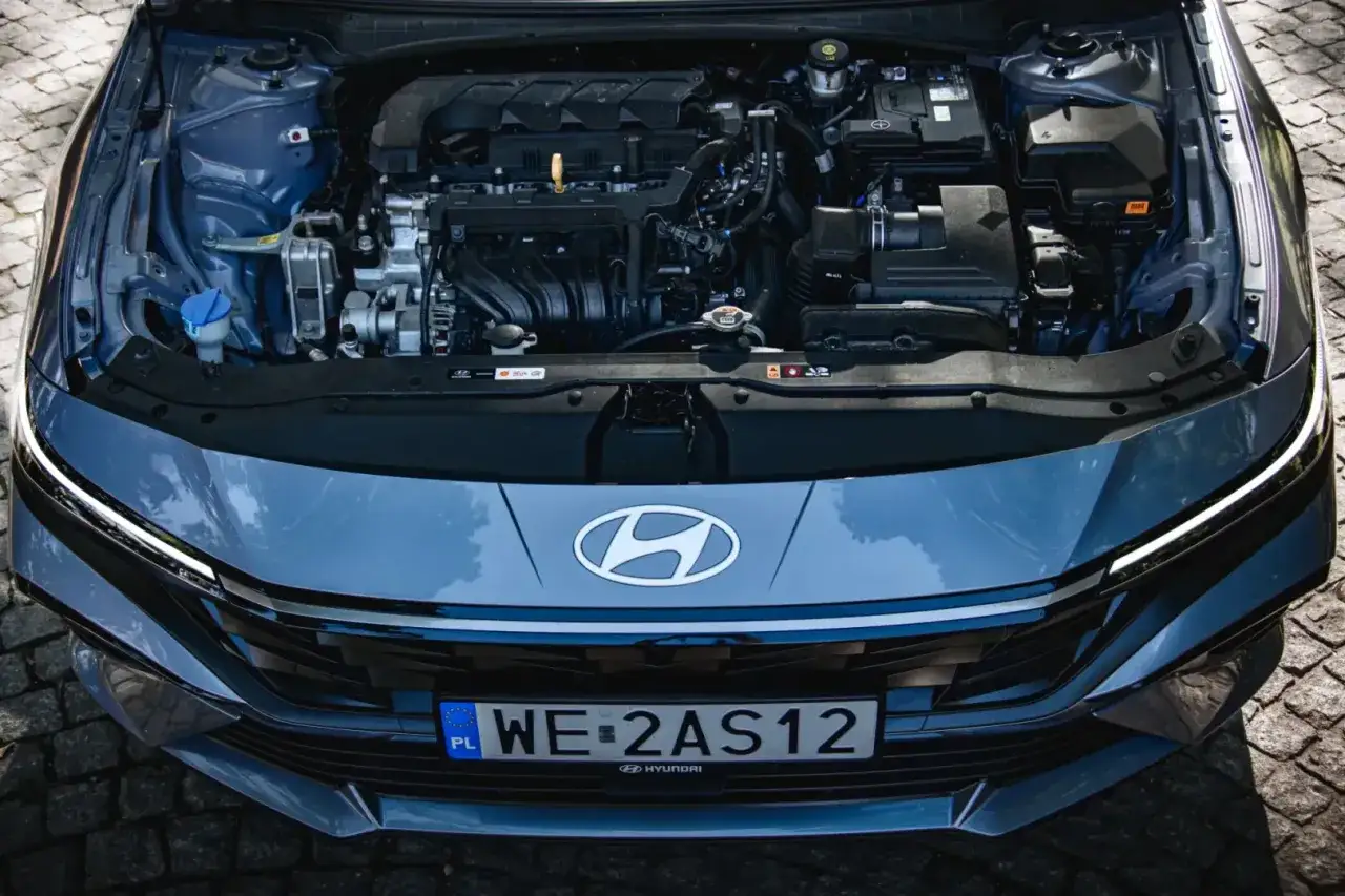 Silnik Hyundai Elantra 2023 pod otwartą maską. Widoczny grill z logo marki i polskie tablice rejestracyjne.
