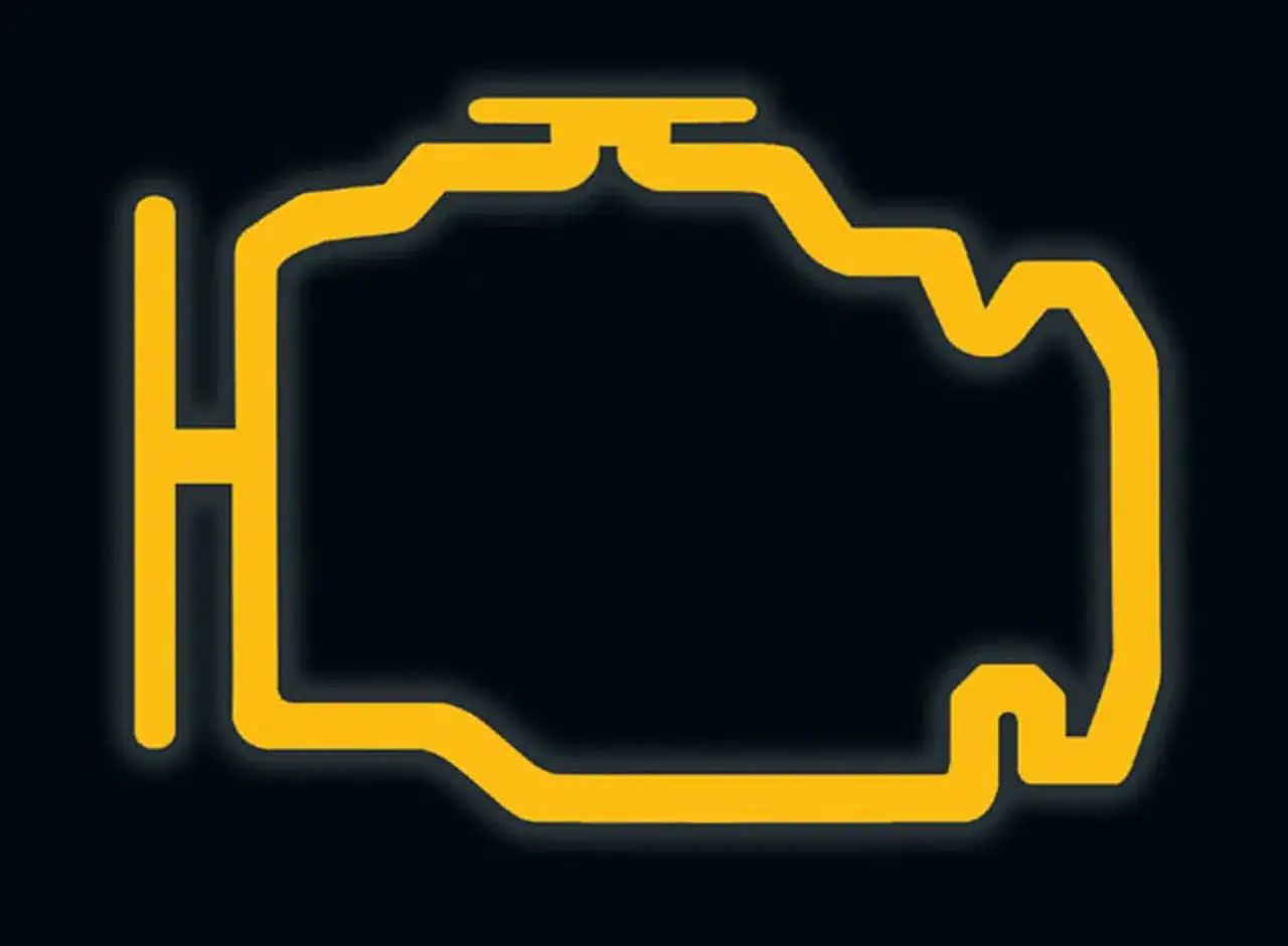Żółta kontrolka check engine na ciemnym tle.