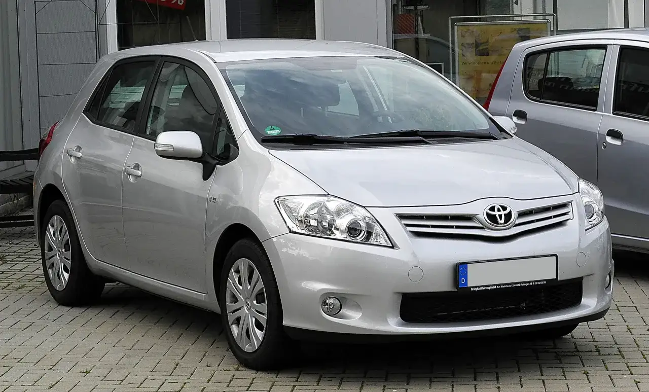 Srebrny Toyota Auris 1.6 benzyna zaparkowany na kostce brukowej.