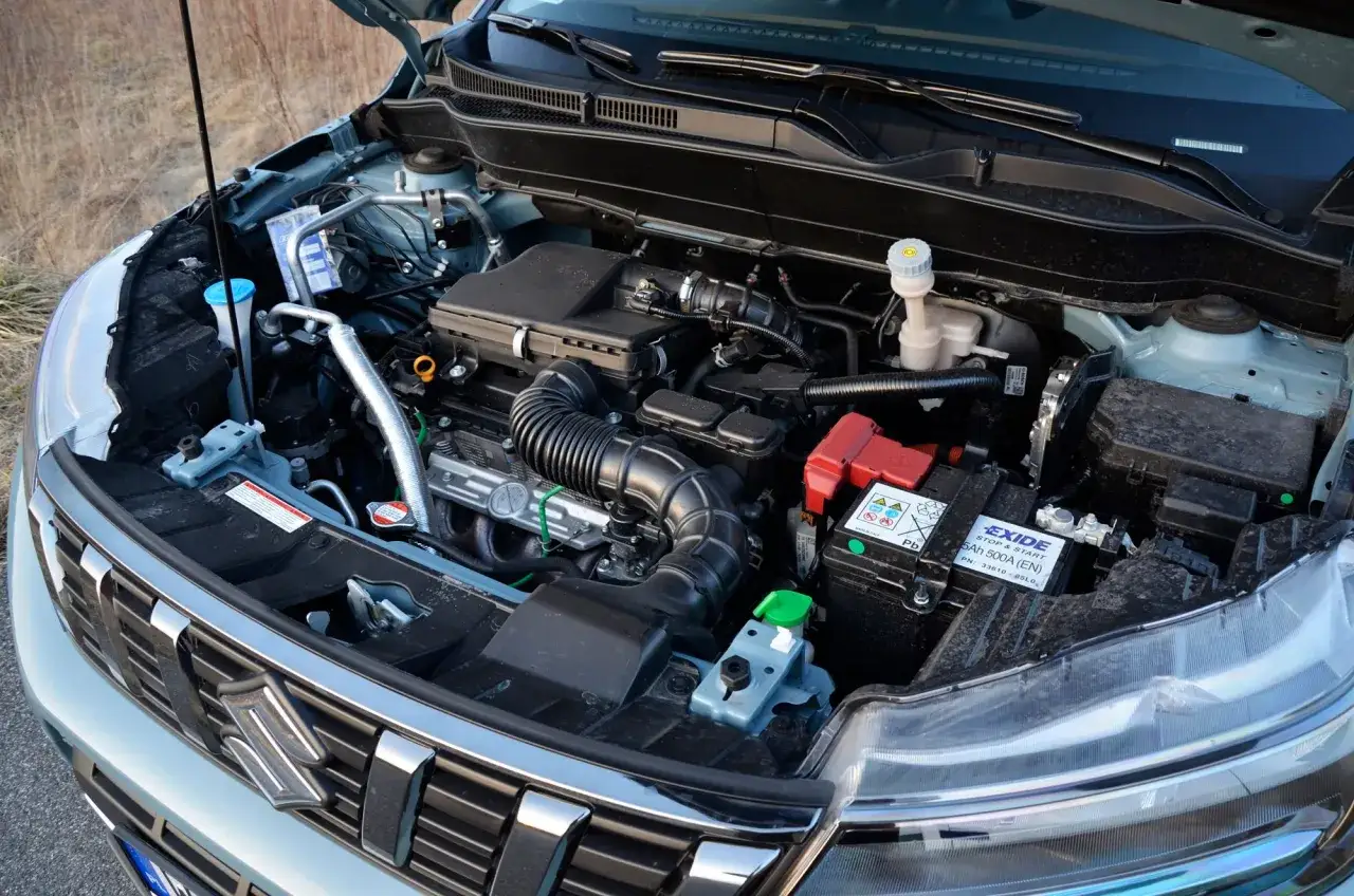Silnik Suzuki Vitara 2023: czysty i uporządkowany, gotowy do drogi. Widać akumulator EXIDE i płyny eksploatacyjne.