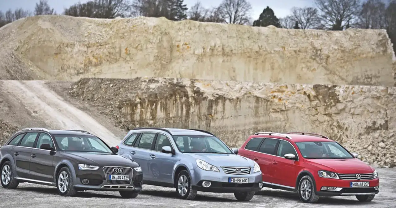 Trzy kombi: ciemny Audi Allroad, jasnoniebieski Subaru i czerwony Volkswagen, stoją na tle kamieniołomu.
