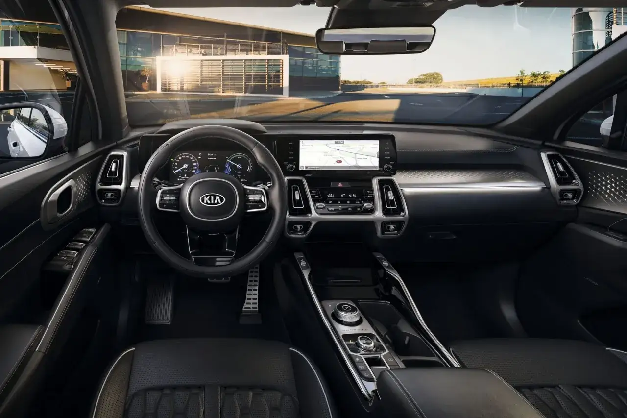 Wnętrze Kia Sorento 2025: nowoczesny kokpit z dużym ekranem nawigacji, cyfrowymi zegarami i eleganckimi detalami.