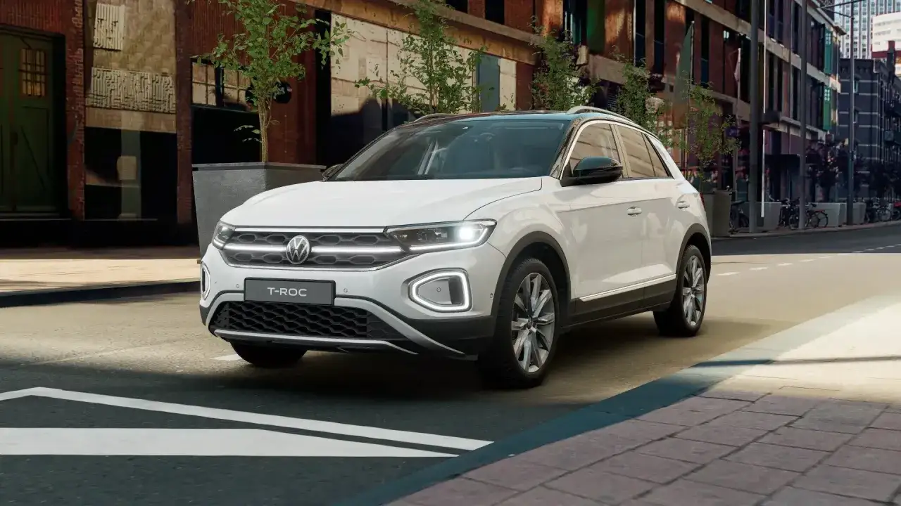 Biały Volkswagen T-Roc na tle miejskiej ulicy. Elegancki SUV gotowy na przygodę w mieście.