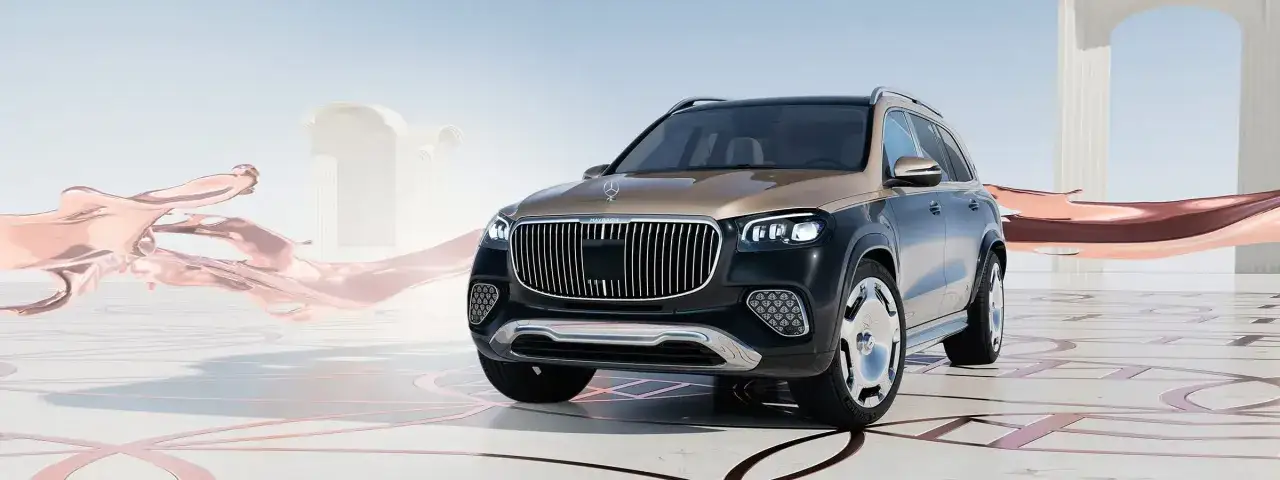 Elegancki Mercedes GLS 2025 w dwukolorowym malowaniu, prezentowany na tle architektonicznych form i płynnych, metalicznych kształtów.