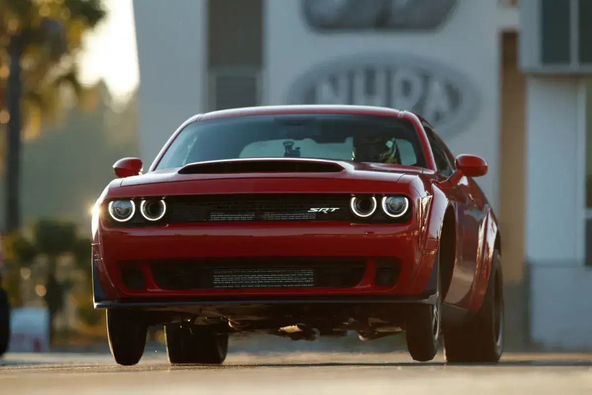 Czerwony Dodge Demon z podniesionym przodem na starcie wyścigu.
