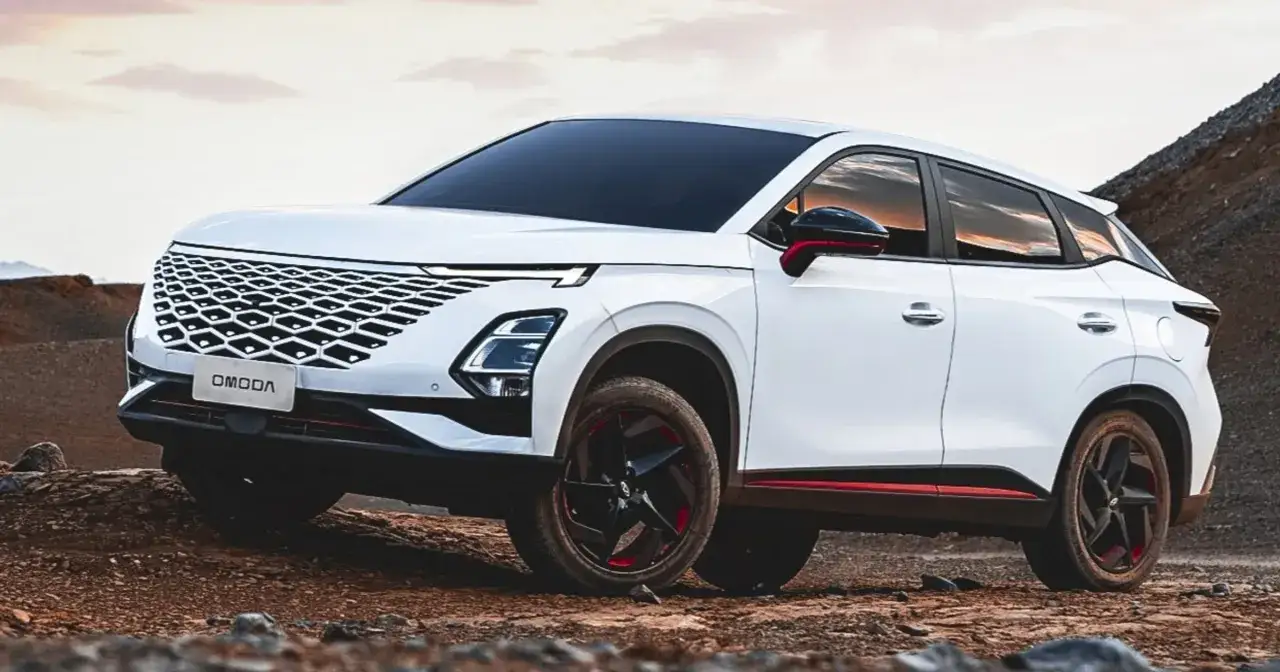 Biały SUV OMODA z charakterystycznym grillem i czerwonymi akcentami na felgach i karoserii, stojący na kamienistym podłożu. Omoda co to za marka?