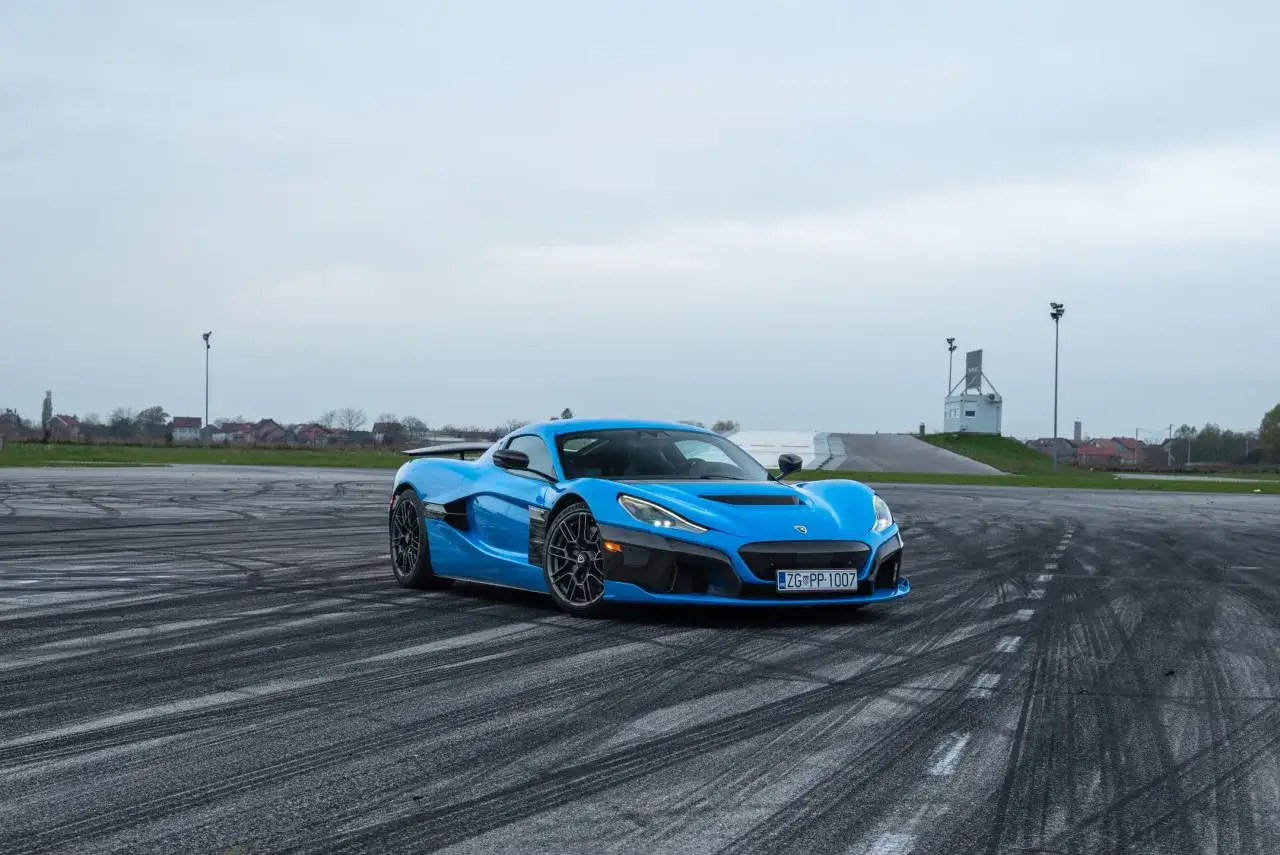 Niebieski Rimac Nevera na torze z widocznymi śladami opon.