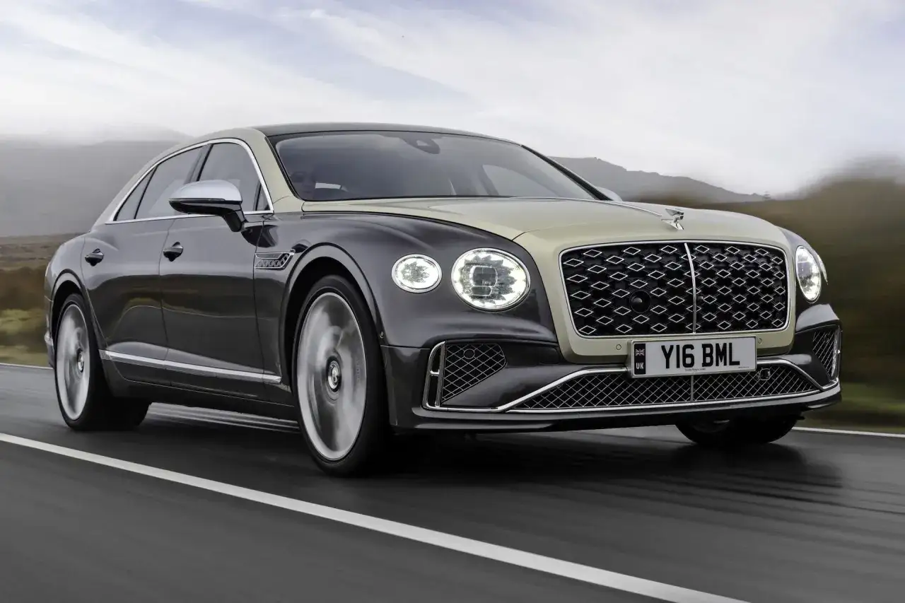 Elegancki Bentley Flying Spur w dwukolorowym malowaniu pędzi po drodze. Sprawdź, jaka jest aktualna bentley cena.