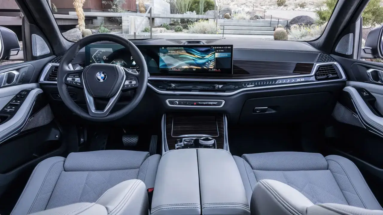 Wnętrze BMW X5 2023 z nowoczesnym ekranem i komfortowymi, jasnymi fotelami.