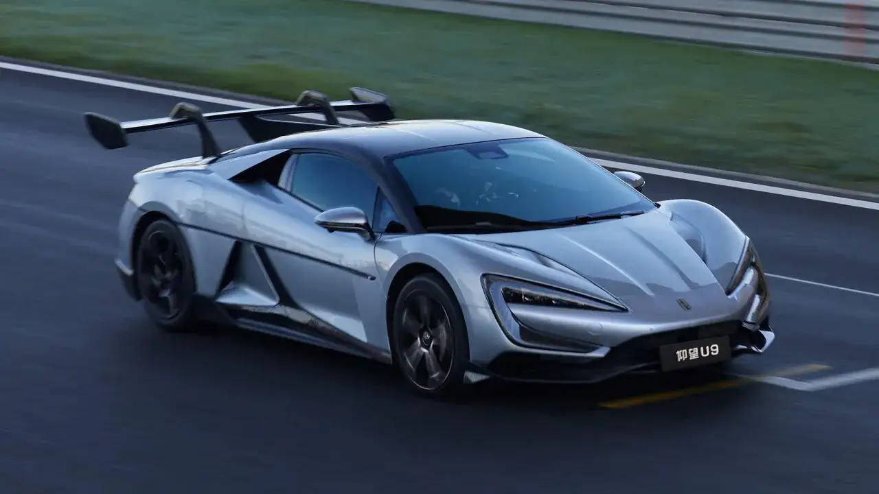 Srebrny supersamochód BYD U9 pędzi po torze wyścigowym, jego aerodynamiczne linie i masywny spoiler podkreślają prędkość.