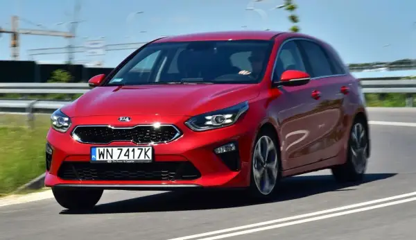 Czerwony Kia Ceed 1.4 benzyna w ruchu drogowym. Elegancki design i dynamiczna jazda.