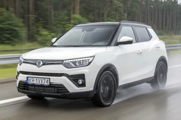 Biały SsangYong Tivoli na mokrej drodze. Wiele osób szuka ssangyong tivoli opinie przed zakupem.