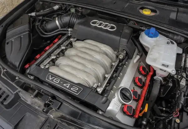 Silnik V8 4.2 Audi, jeden z najlepszych silników benzynowych, z widocznymi cewkami zapłonowymi i kolektorem dolotowym.