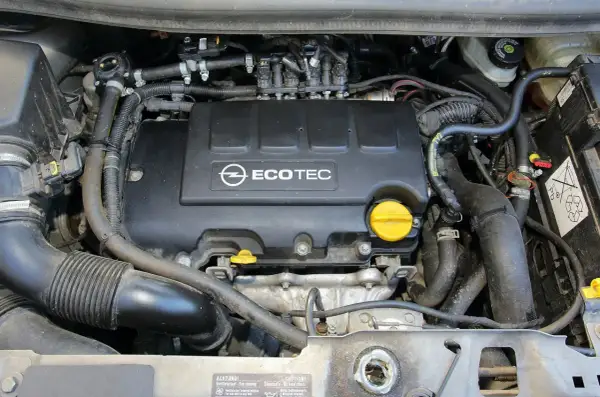 Silnik Ecotec w Oplu Meriva 1.4 benzyna. Widoczne przewody, wtryskiwacze i osłona silnika.