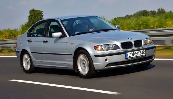 Srebrne BMW E46 330d na drodze. Kierowca w kratę, pozytywne opinie o tym modelu.
