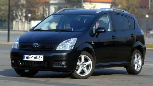 Czarny Toyota Verso z polskimi tablicami WE 1606F zaparkowany na ulicy.