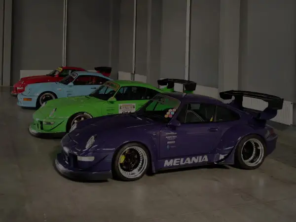 Kolekcja Porsche RWB w jaskrawych kolorach: fioletowy, zielony, błękitny i czerwony, z charakterystycznymi spojlerami i szerokimi nadkolami.