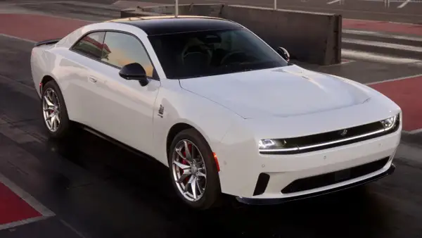 Biały Dodge Daytona z czarnym dachem na torze wyścigowym, gotowy do startu.
