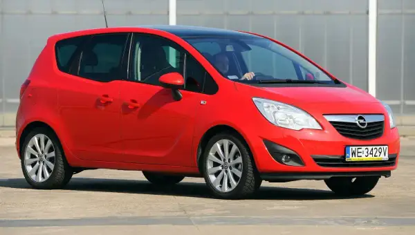 Czerwony Opel Meriva 1.6 benzyna z czarnym dachem, zaparkowany na zewnątrz.
