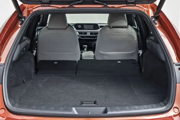 Widok bagażnika Lexusa UX z rozłożonymi tylnymi siedzeniami. Sprawdź lexus ux wymiary, by poznać jego pojemność.