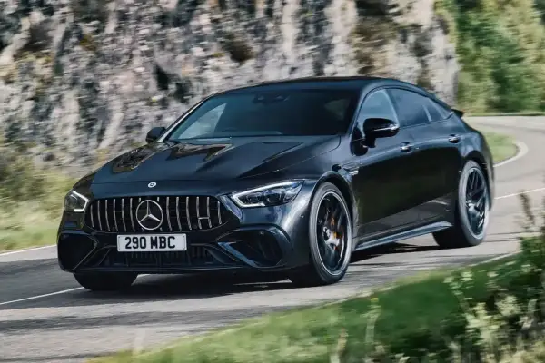 Czarny Mercedes-AMG GT 63 S na zakręcie górskiej drogi.