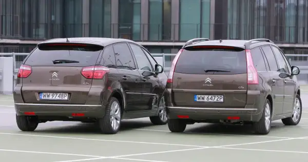 Dwa brązowe Citroen Picasso stoją obok siebie na parkingu.