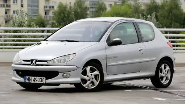 Srebrny Peugeot 206 1.4 benzyna z polskimi tablicami rejestracyjnymi na parkingu.