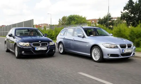Dwa BMW E90 2.0 benzyna jadące obok siebie. Jeden to ciemny sedan, drugi to jasny kombi.